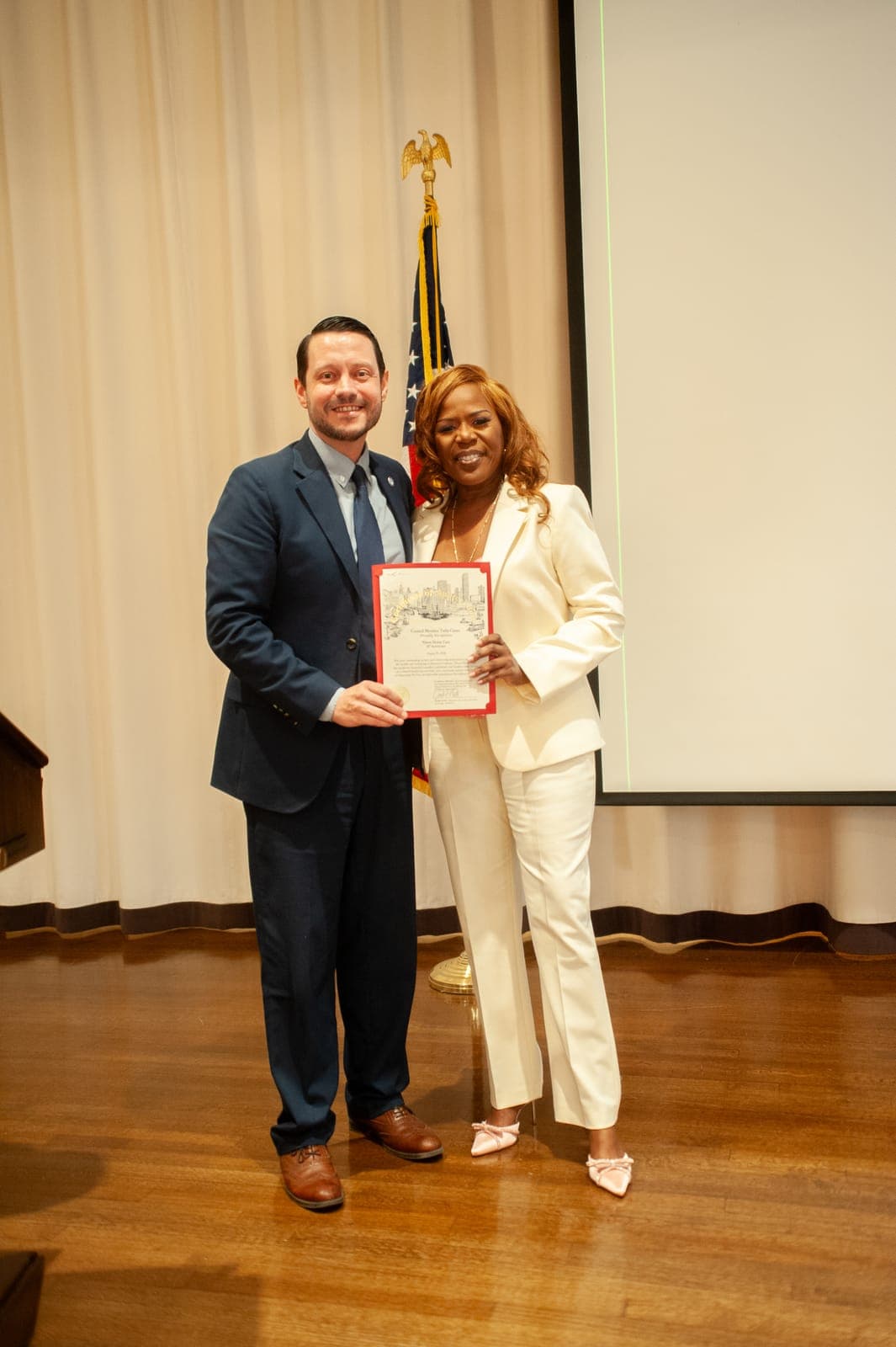 Debora Nixon receiving a framed proclamation from an official