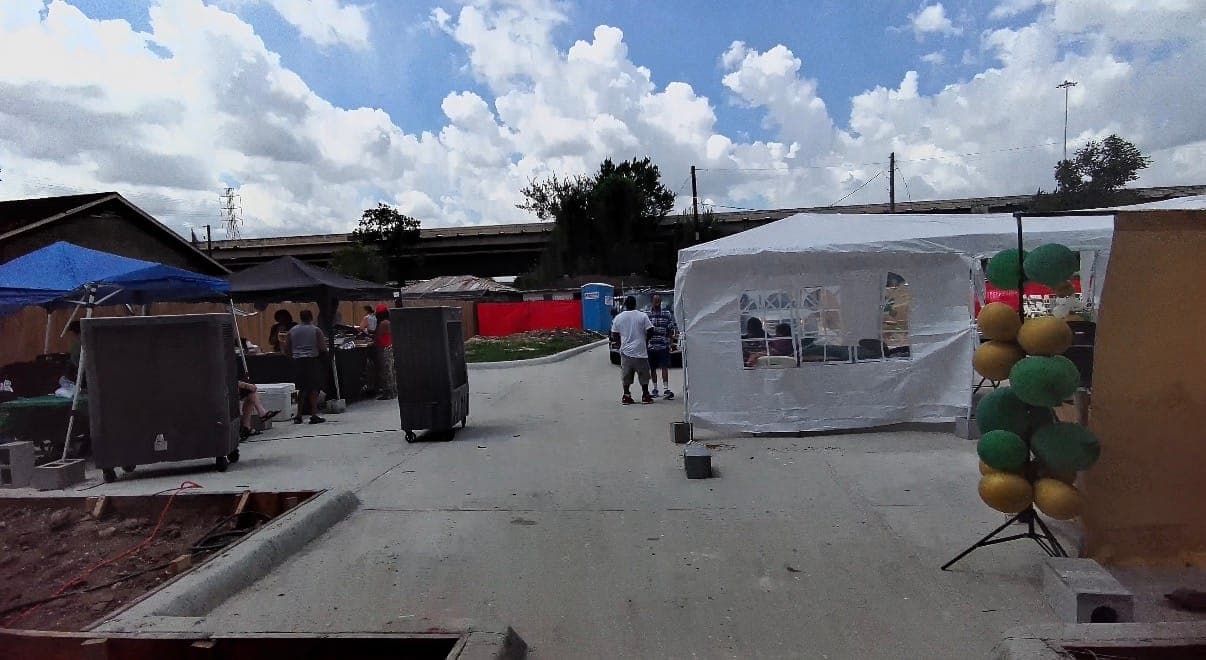 Ground-level view of the event lot with balloons and tents set up