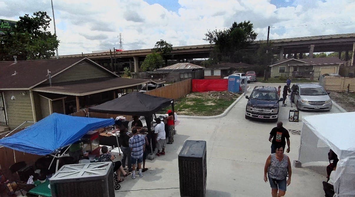 Street-level view of the event with parked cars and guests walking in